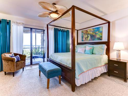 a bedroom with a canopy bed and a chair at Sea Matanzas 2 in Saint Augustine
