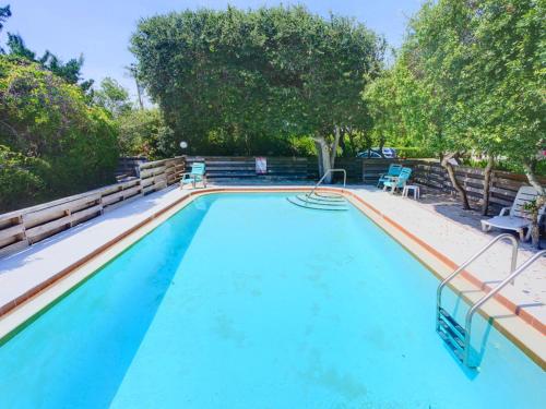 a large swimming pool with blue chairs and trees at Sea Matanzas 2 in Saint Augustine