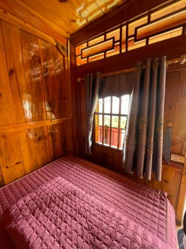 a bed in a wooden room with a window at Homestay Chân Mây Chiêu Lầu Thi in Hoàng Su Phì