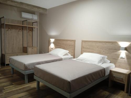 2 letti in camera d'albergo con 2 lampade di Masseria Spinale Wine Resort a Melfi