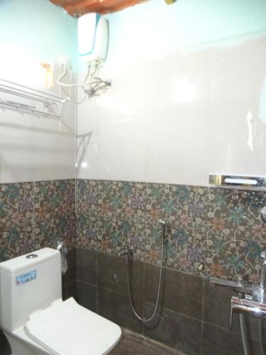 a bathroom with a shower and a toilet in it at MangoHut Farmhouse Pool Villa in Hyderabad