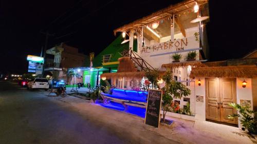 a building with blue lights on a street at night at Al Kabron Inn in Karimunjawa