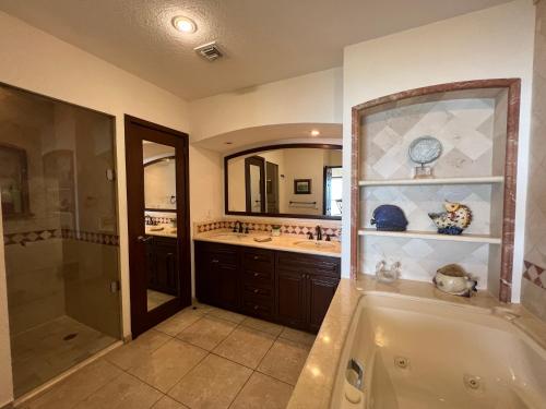 een badkamer met een bad, een douche en een wastafel bij Sonoran Sky in Puerto Peñasco