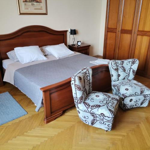 a bedroom with a bed and a chair at APARTMAN FLAVIA in Rijeka