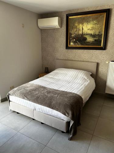 a bedroom with a bed with a painting on the wall at Parel van Bever - Perle de Biévène in Bever