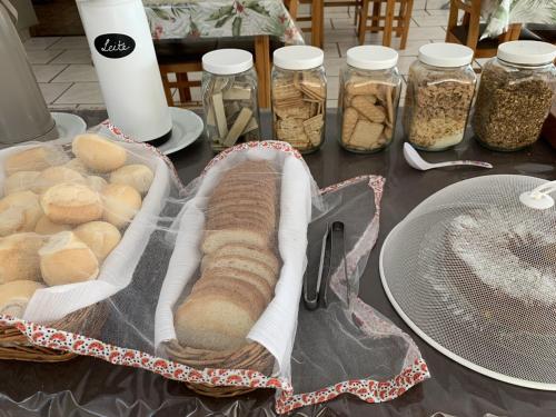 a table with a basket of bread and jars of food at Ouro Hotel in Ourinhos