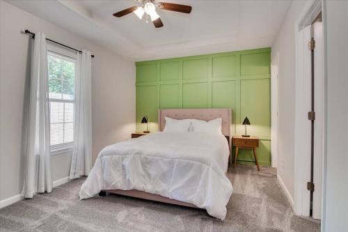 a bedroom with a bed and a green wall at The Masters Cottage by Augusta National in Augusta