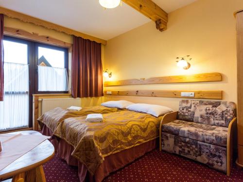 une chambre d'hôtel avec deux lits et une chaise dans l'établissement Willa Widokowa Wojnar, à Zakopane