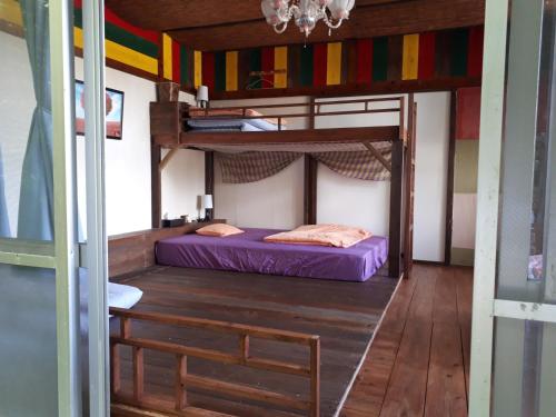 名護市にあるbackpackers guesthouse Borderの二段ベッド2台とテーブルが備わる客室です。