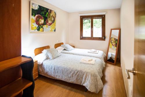 a bedroom with two beds and a mirror at La Huerta, megustarural in Llanes