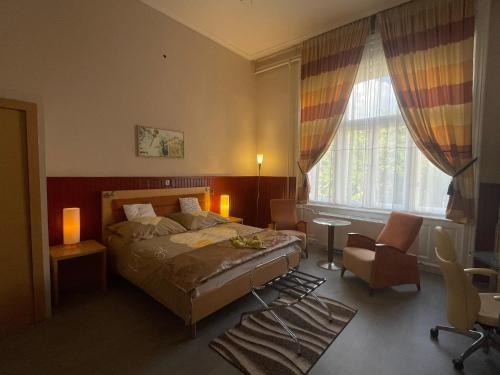 a bedroom with a bed and a desk and a window at Meller-kastély Villa in Csurgó