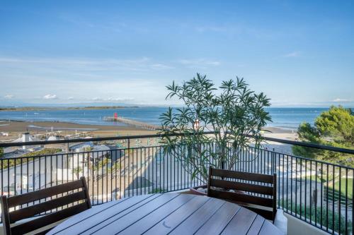 a balcony with a table and a view of the beach at La terrazza sul faro in Lignano Sabbiadoro