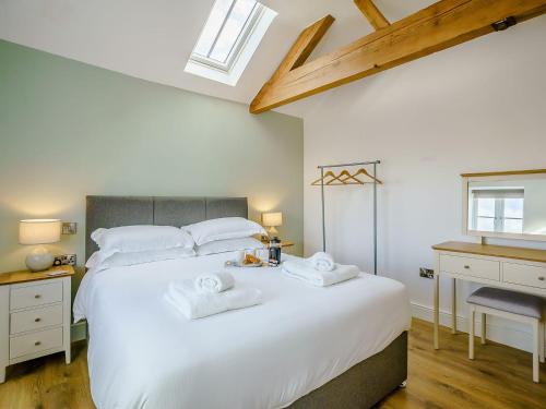 een slaapkamer met een groot wit bed en handdoeken bij Cor Tarw - Uk12743 in Acrefair