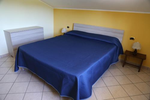 a blue bed in a room with a yellow wall at La Masseria PietraMarmo Caiazzo - App to con vista in Caiazzo
