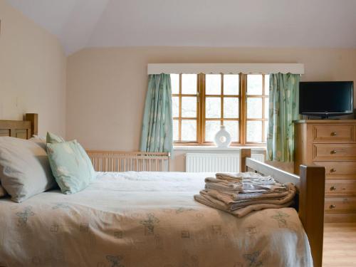 a bedroom with a bed with a television and a window at Springfields in Leek