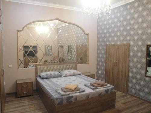 a bedroom with a bed with a large mirror at apartament oriental tale in old cyti Baku in Baku