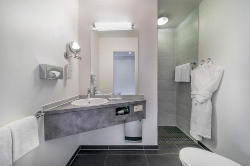 オーバーハウゼンにあるHotel Oberhausen Neue Mitte affiliated by Meliáの洗面台とトイレ付きのバスルーム