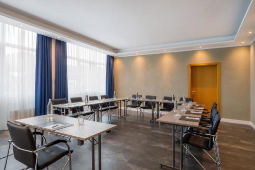 a conference room with tables and chairs and windows at Hotel Oberhausen Neue Mitte affiliated by Meliá in Oberhausen