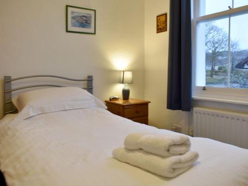 - une chambre avec un lit blanc et des serviettes dans l'établissement Robinson, à Keswick