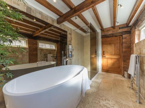 a bathroom with a white tub and a wooden ceiling at The Old Rope Works in Bewdley