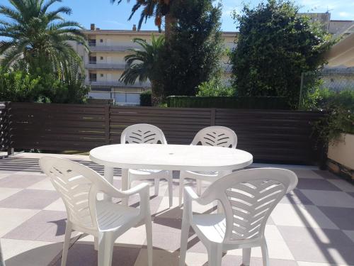 a white table and four white chairs on a patio at Payet Apartments in L'Estartit