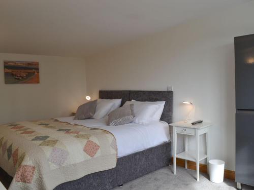 a bedroom with a bed and a side table at Moss Hall Barn in Eaton