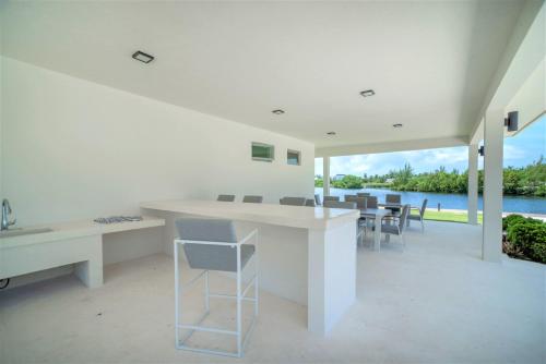 a white dining room with a table and chairs at Cayman Luxury Rentals at One Canal Point in Upper Land