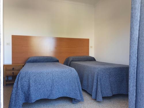 two beds with blue covers in a room at Payet Apartments in L'Estartit