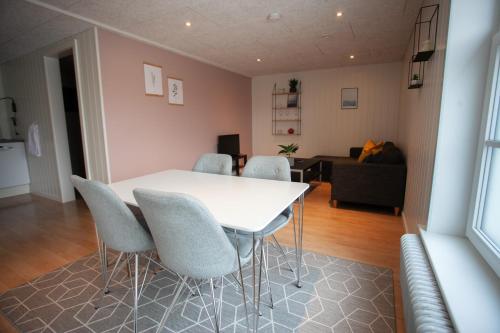 a dining room with a white table and chairs at Jotunheim / Aparthotel / Family Friendly in Miðvágur