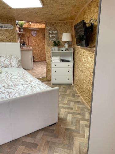 a bedroom with a white bed and a kitchen at Pen-Y-Bryn Annex in Brynmenin