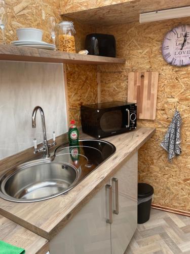 a kitchen with a sink and a microwave at Pen-Y-Bryn Annex in Brynmenyn