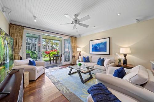 a living room with white furniture and a ceiling fan at Turtle Bay Villas 205 in Kahuku