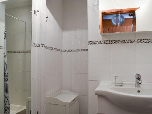 a white bathroom with a sink and a toilet at Poppy Lodge in Kingsdown