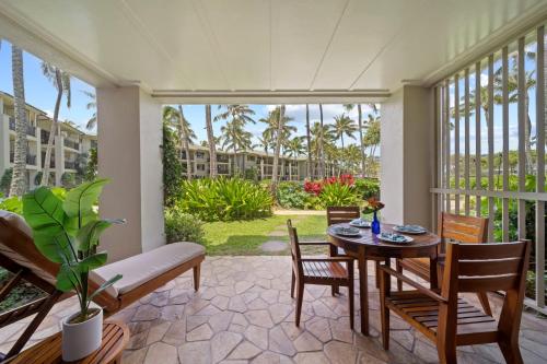 a dining room with a table and chairs and a balcony at Turtle Bay Villas 205 in Kahuku