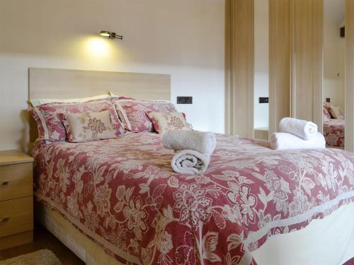 a bedroom with a bed with a red and white blanket at Little Hendre Lodge - Uk10262 in Penrhôs