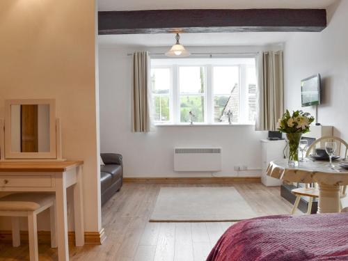 a living room with a bed and a window at Weavers Houses in Hayfield