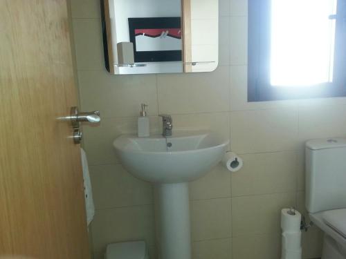 a bathroom with a sink and a mirror and a toilet at Apartment Mojon Hills in Isla Plana