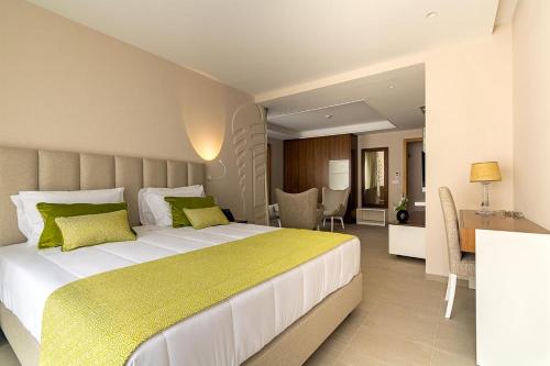 a bedroom with a large bed with green pillows at Luna Boutique Hotel in Mindelo