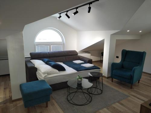 a living room with a couch and two blue chairs at Sky Luxury in Arandjelovac
