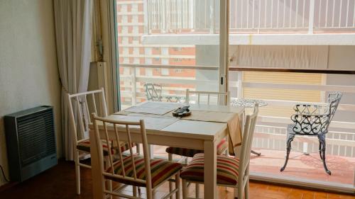 a table and chairs in a room with a window at Departamento en la PLAYA Y CENTRO de Miramar para 3 personas in Miramar