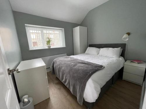 a bedroom with a bed and a window at Tonn Ruray Sea View Luxury 2 Bed Apartment in Dundrum