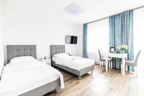 キェルツェにあるEXPO HOSTELのベッド2台とテーブルと机のある寝室