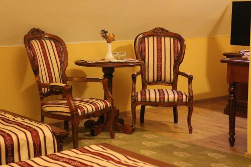 a room with two chairs and a table with a vase at Hotel Astoria in Satu Mare