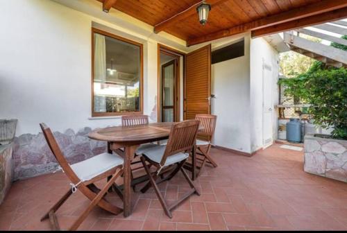 einen Holztisch und Stühle auf einer Terrasse in der Unterkunft Geremeas Country Club in Torre delle Stelle