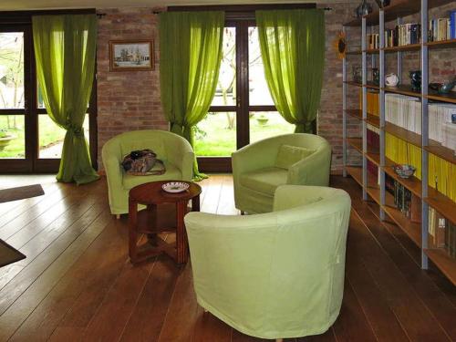uma sala de estar com cadeiras verdes e uma mesa em Locanda Del Molino Vecchio em Magliano Alfieri
