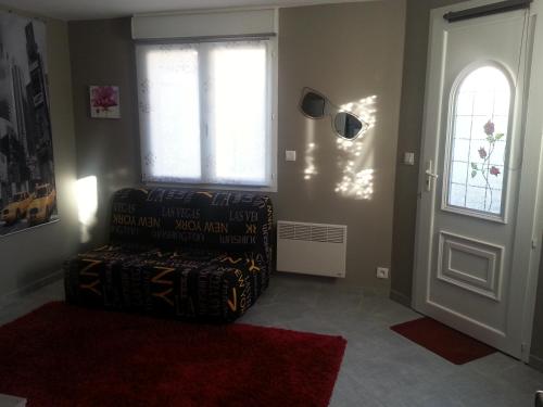 a living room with a chair next to a door at Un petit coin de paradis in Taradeau