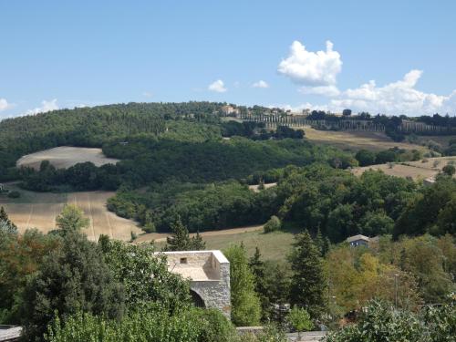 een uitzicht op een heuvel met bomen en een gebouw bij Scappo in Umbria, La casa di Soel in Amelia