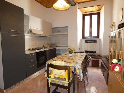 een keuken met een tafel met stoelen en een wastafel bij Scappo in Umbria, La casa di Soel in Amelia