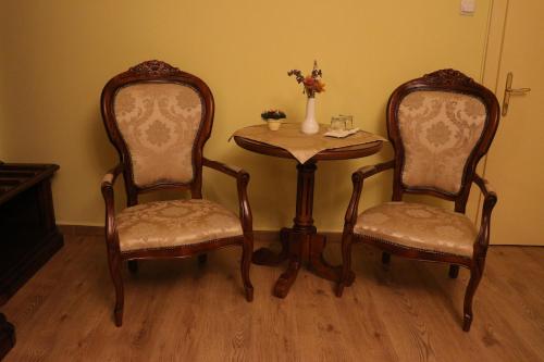 a table and two chairs and a table and a table and chairs at Hotel Astoria in Satu Mare
