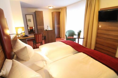 a hotel room with a bed with white pillows at Hotel Sonneck in Schwäbisch Hall